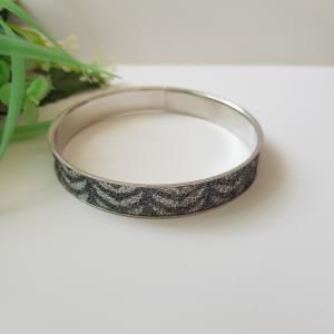 Ezüst-szürke színű, csillogós, hullám mintás karkötő, karperec