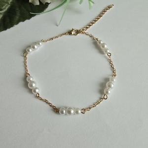 Aranyszínű, fehér gyöngyös karkötő, karlánc