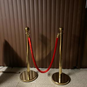 2 darabos aranyszínű tömegirányító oszlopszett piros bársonykötéllel – 96 cm, 1,5 m kötélhosszal, rozsdamentes acél