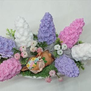 Orgona szappanvirág csokor csónak alakú kaspóban kis alvó őzikével