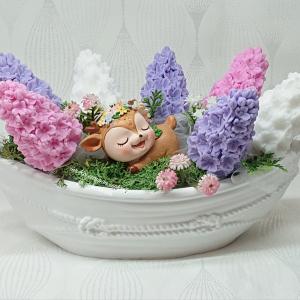 Orgona szappanvirág csokor csónak alakú kaspóban kis alvó őzikével