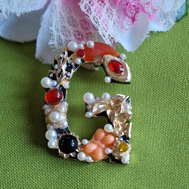 Kitűző, bross BRO42 - Strasszköves gyöngyös pillangós G betű 35x50mm