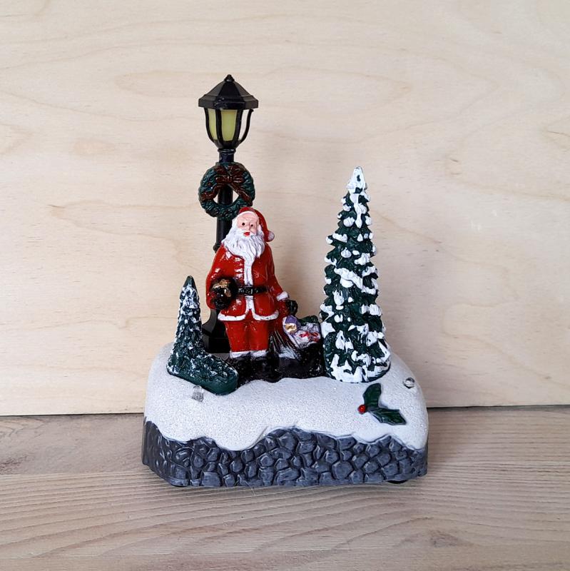 Karácsonyi faluhoz figura: Mikulás kandeláberrel, ledes, műanyag. Mérete: 95x125x55 mm