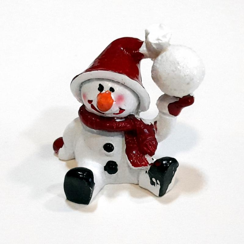 Ülő hóember figura kezében hógolyóval. Mérete: 40x30 mm