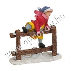 Kislány átmászik a kerítésen